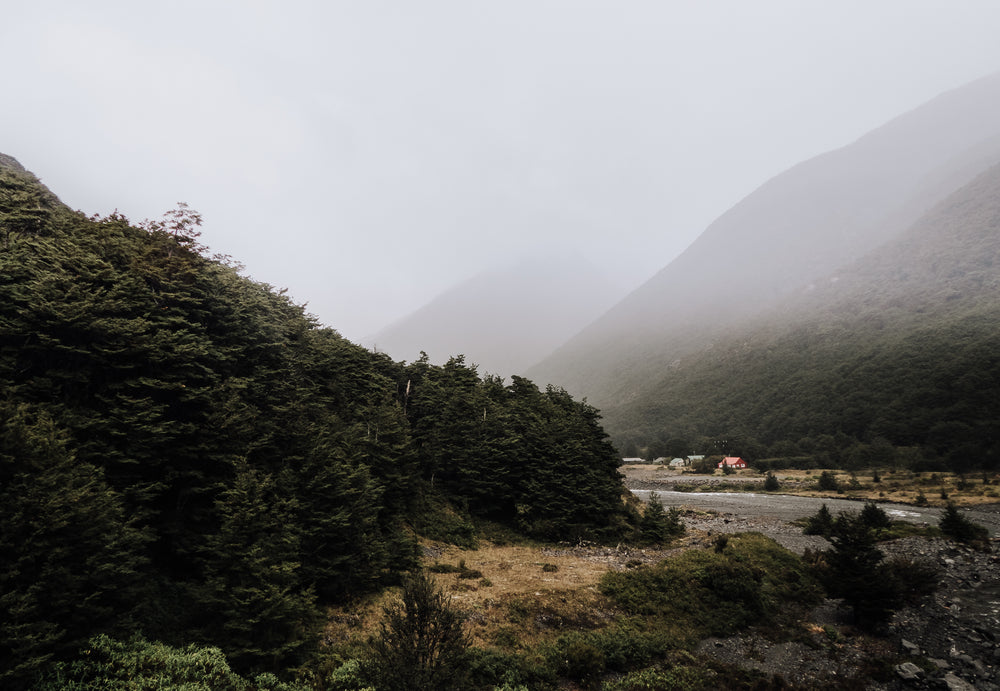 misty mountain valley and a huddle of woodland huts