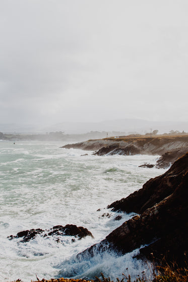 misty ocean coast with crashing waves