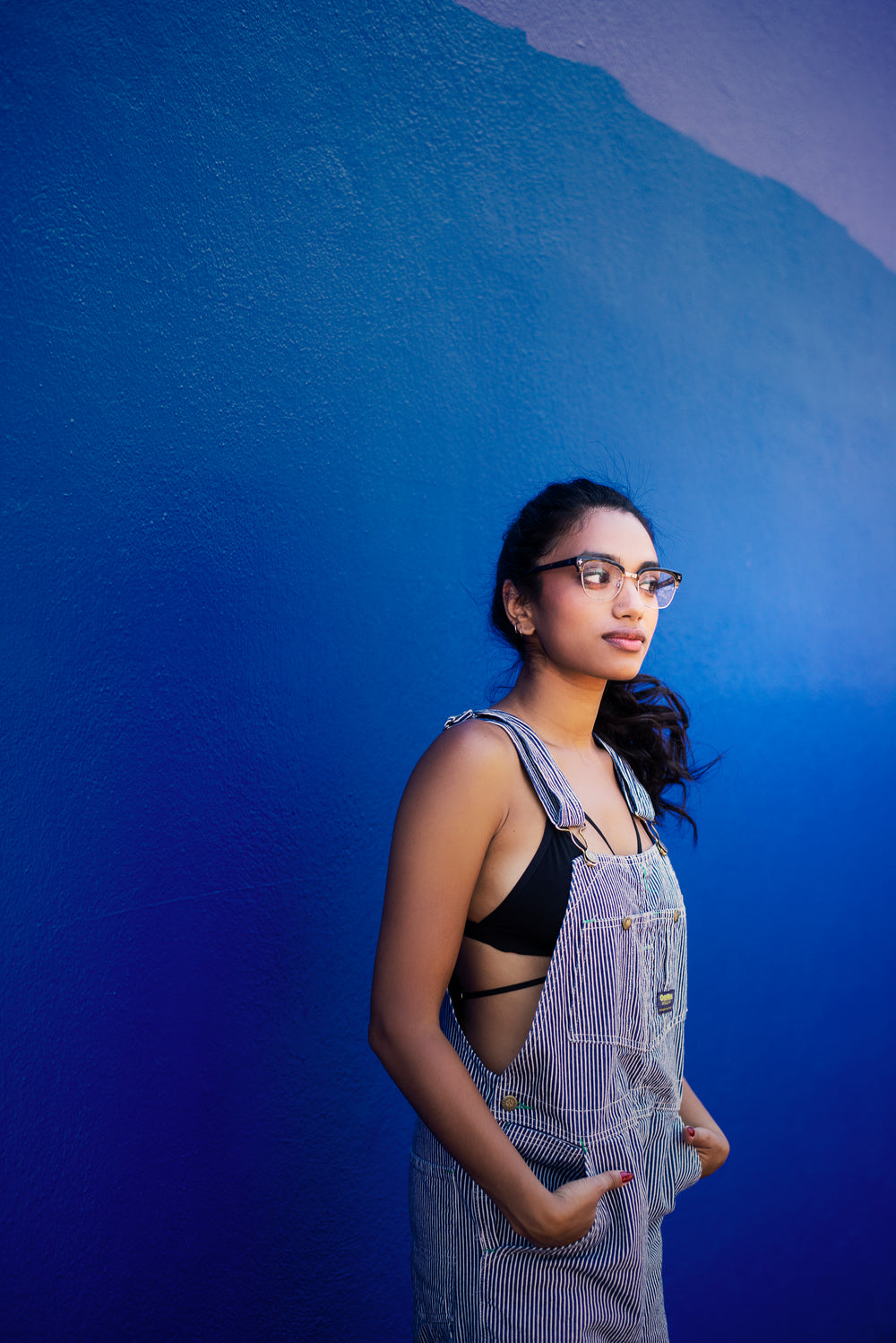 model in glasses and overalls