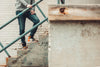 model poses on cement stairs in denim and sneakers
