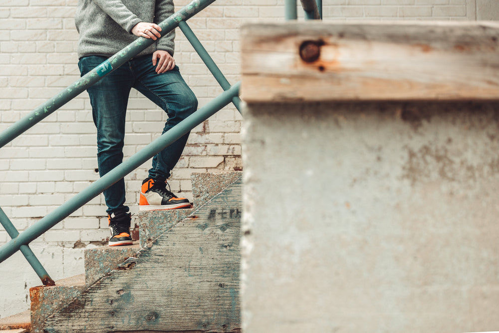 model poses on cement stairs in denim and sneakers