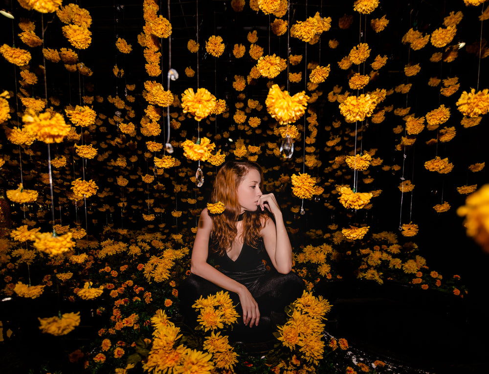 model poses with hanging flowers
