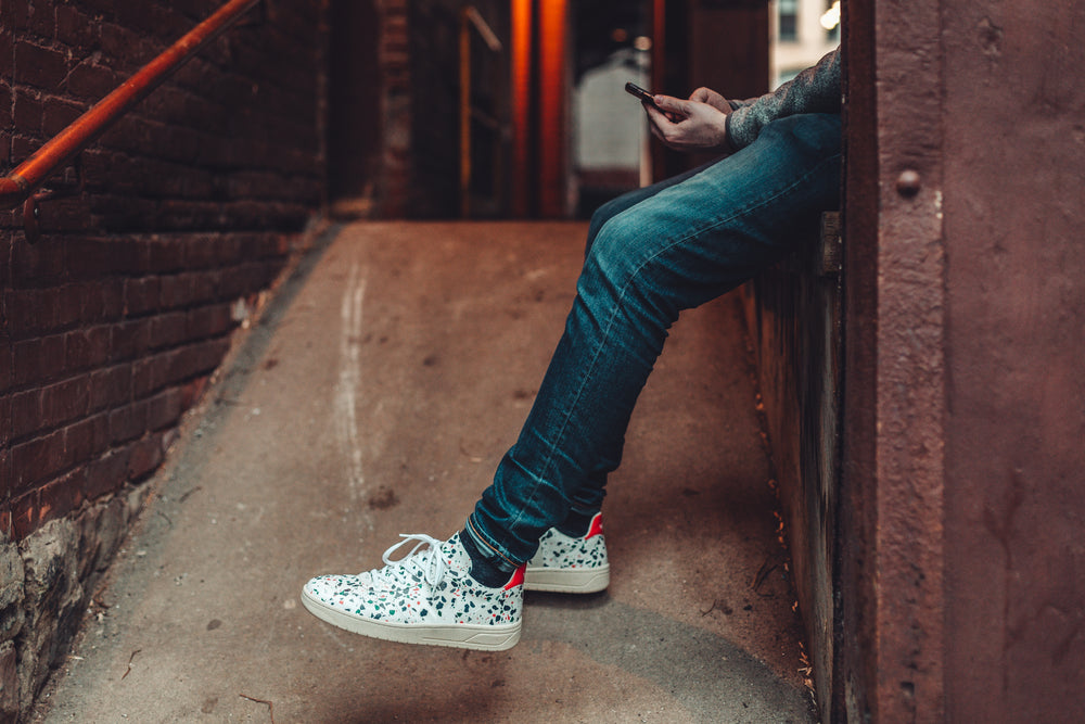 model sitting quietly on cement wall to check their phone