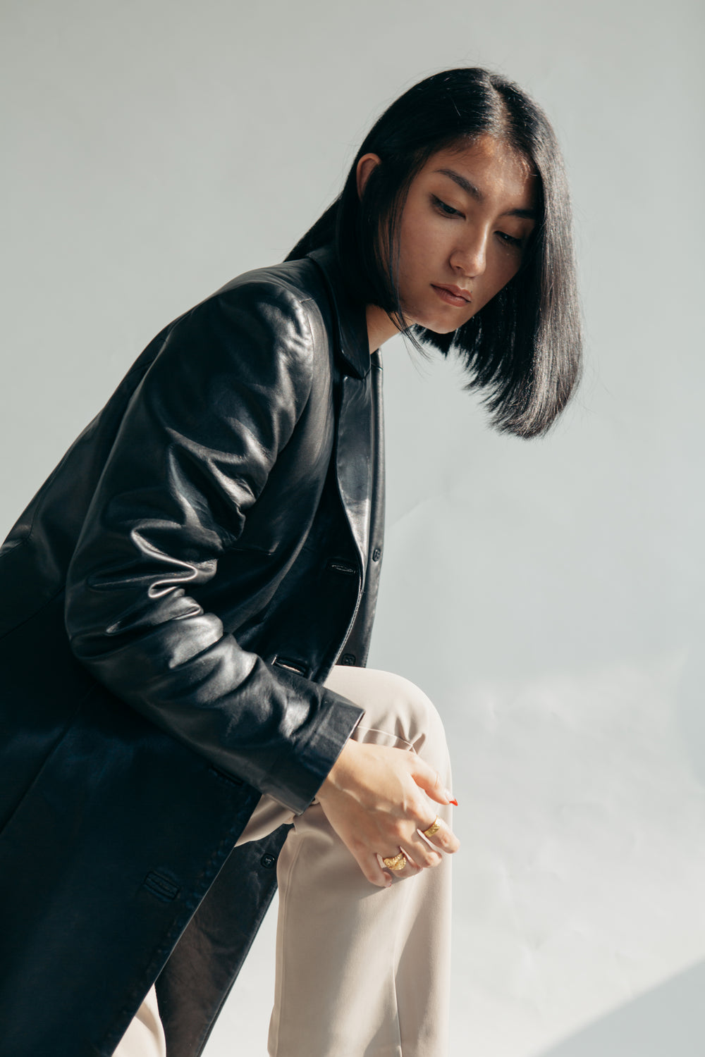 model wearing leather jacket and tan pants