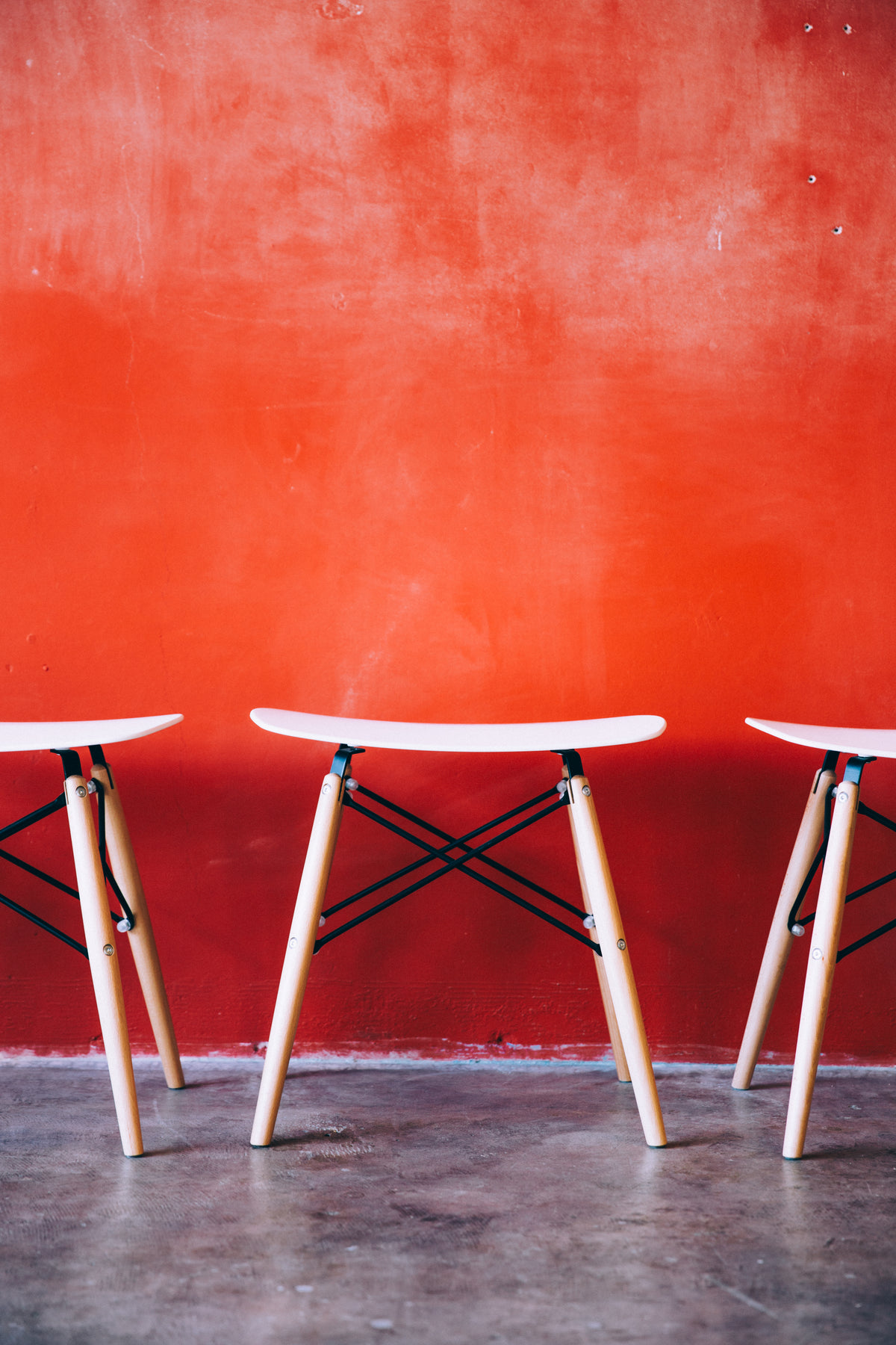 modern stools by red wall