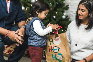Imagens de Mãe e pai ajudam o filho a abrir o presente de natal