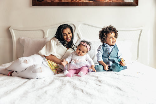 mom with daughter and son on bed