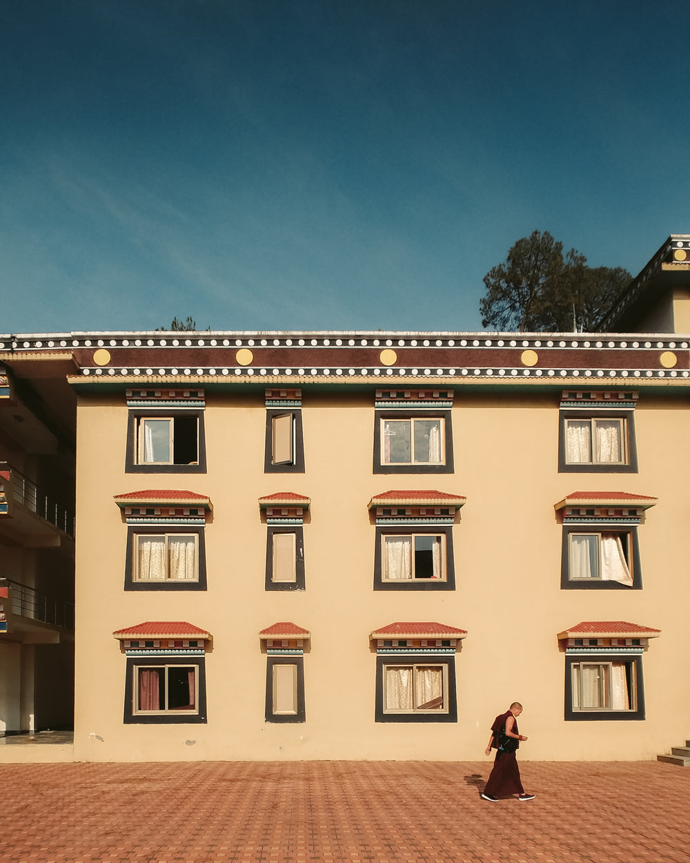 monk walks past building