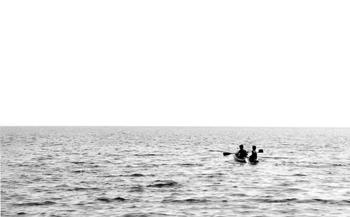 monochrome image of a small boat on open water