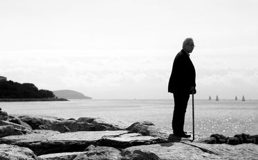 monochrome man standing alone looking beyond the shore