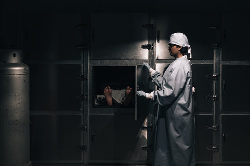 morgue attendant closing a freezer