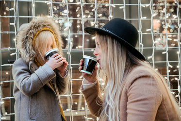 mother daughter sharing hot beverages