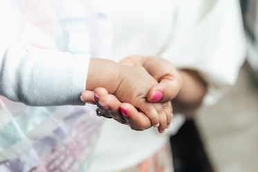 mother holding babies hand