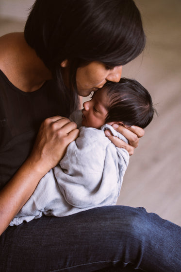 mother kissing newborn