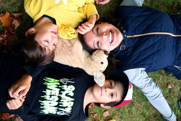 mother laughing with her children in grass