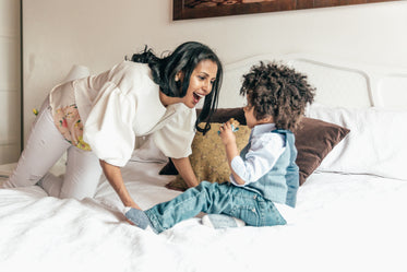 mother playing with son in bedroom