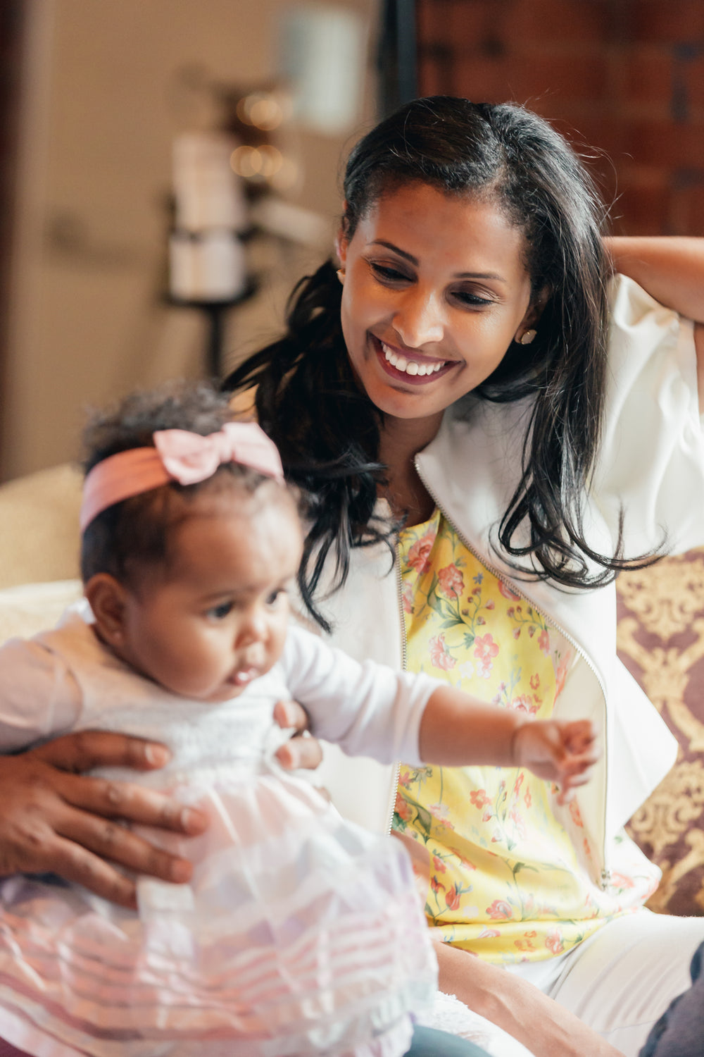 mother smiles looking at baby daughter