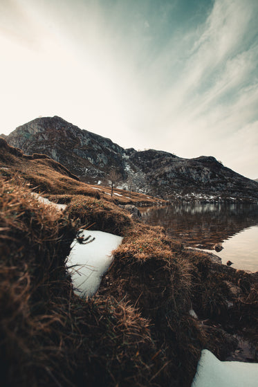 mountain stands at the edge of a lake