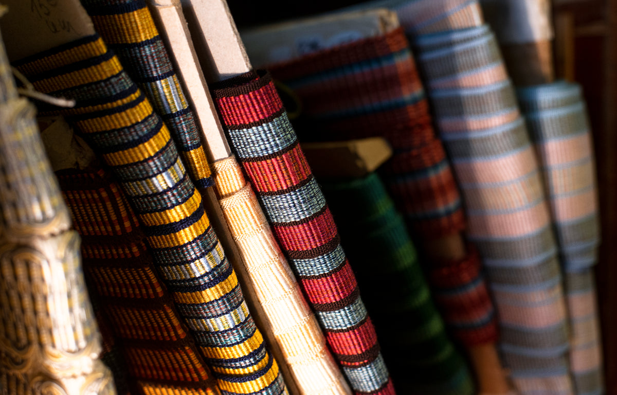 multi-colored and patterned rolls of ribbon on a shelf