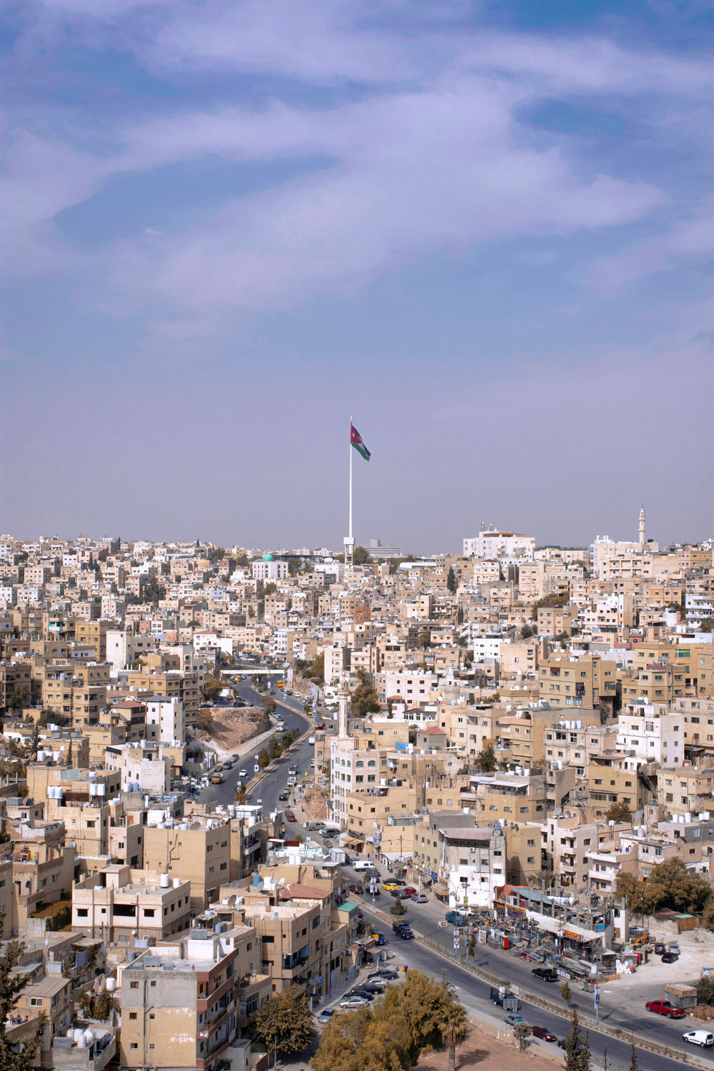 national flag of jordan over city of jerash