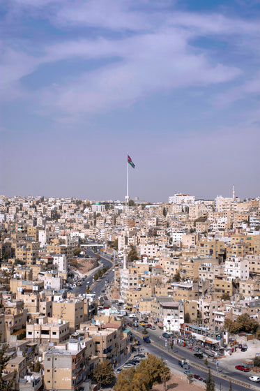 national flag of jordan over city of jerash