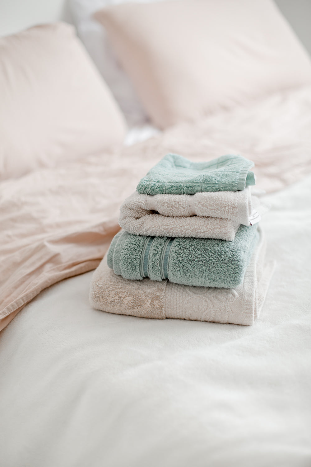 neatly folded towels placed on a bed