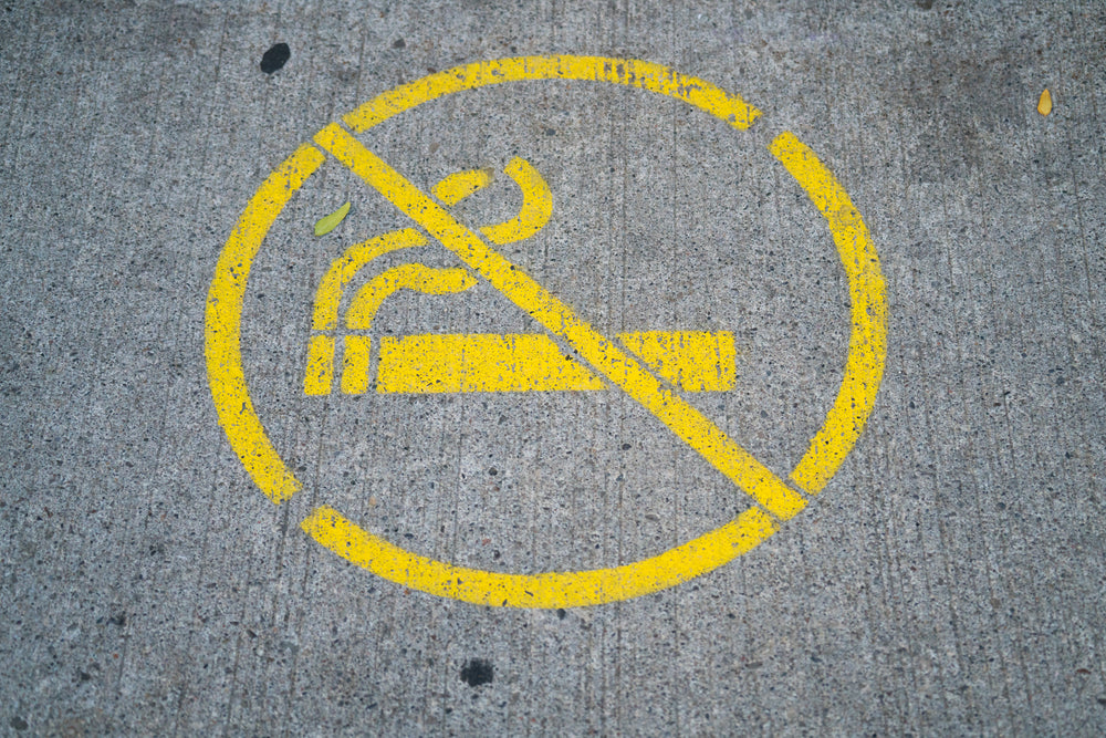 no smoking sign on sidewalk