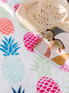 notebook sunhat and sunglasses on pineapple table cloth