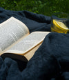 novel lays open on a blue linen blanket