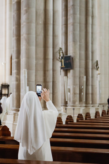 nun snaps a photo in an old church