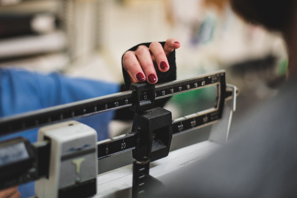 nurse adjusts the dials on a weight apparatus