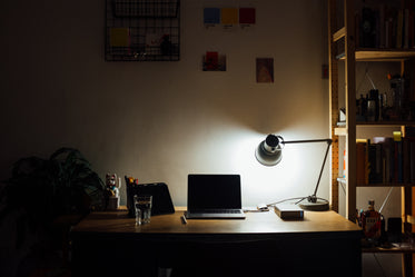 objects on a desk throw shadows from a lamp