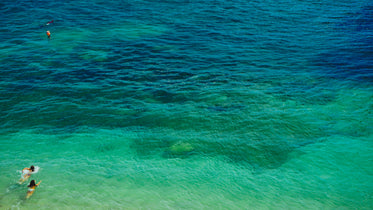 ocean water with swimmers