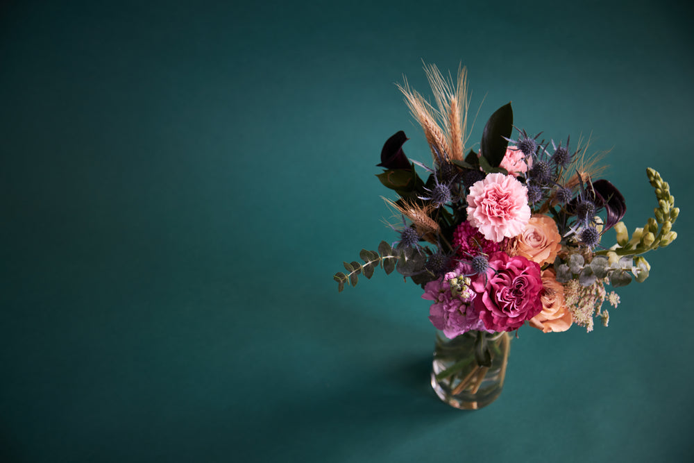 off center vivid floral bouquet in clear vase