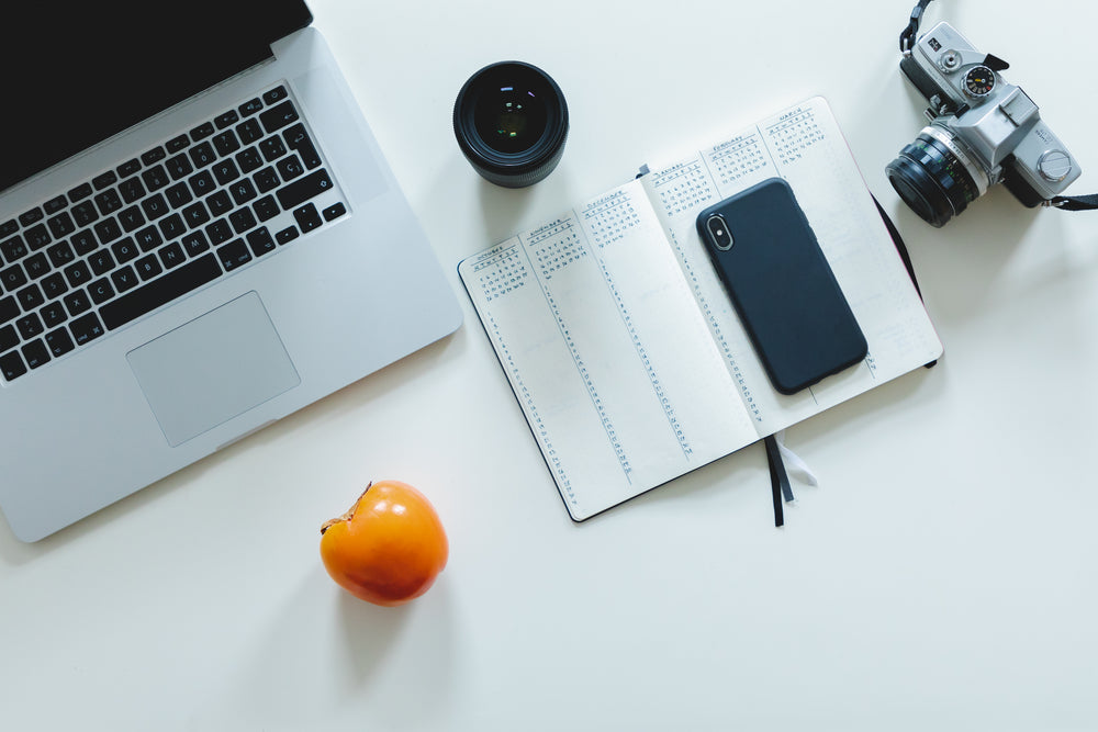 office flatlay with camera gear and orange fruit