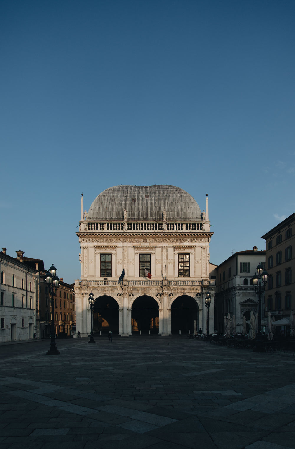 old white building at the edge of a town square