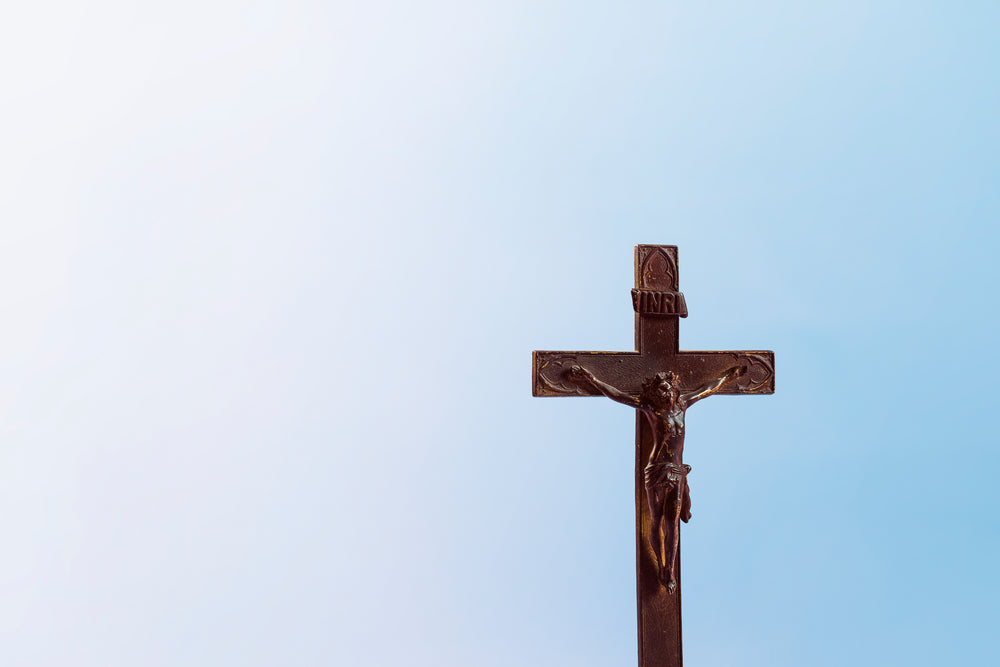 old wooden cross on blue background