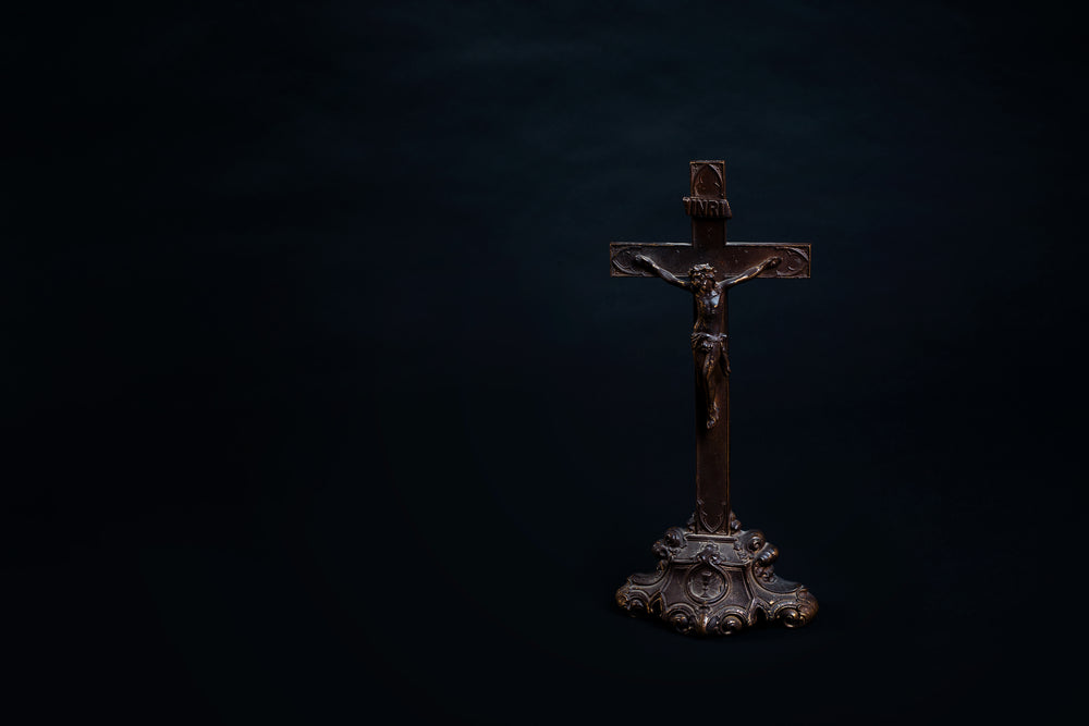 old wooden cross with carved figure and ornate stand