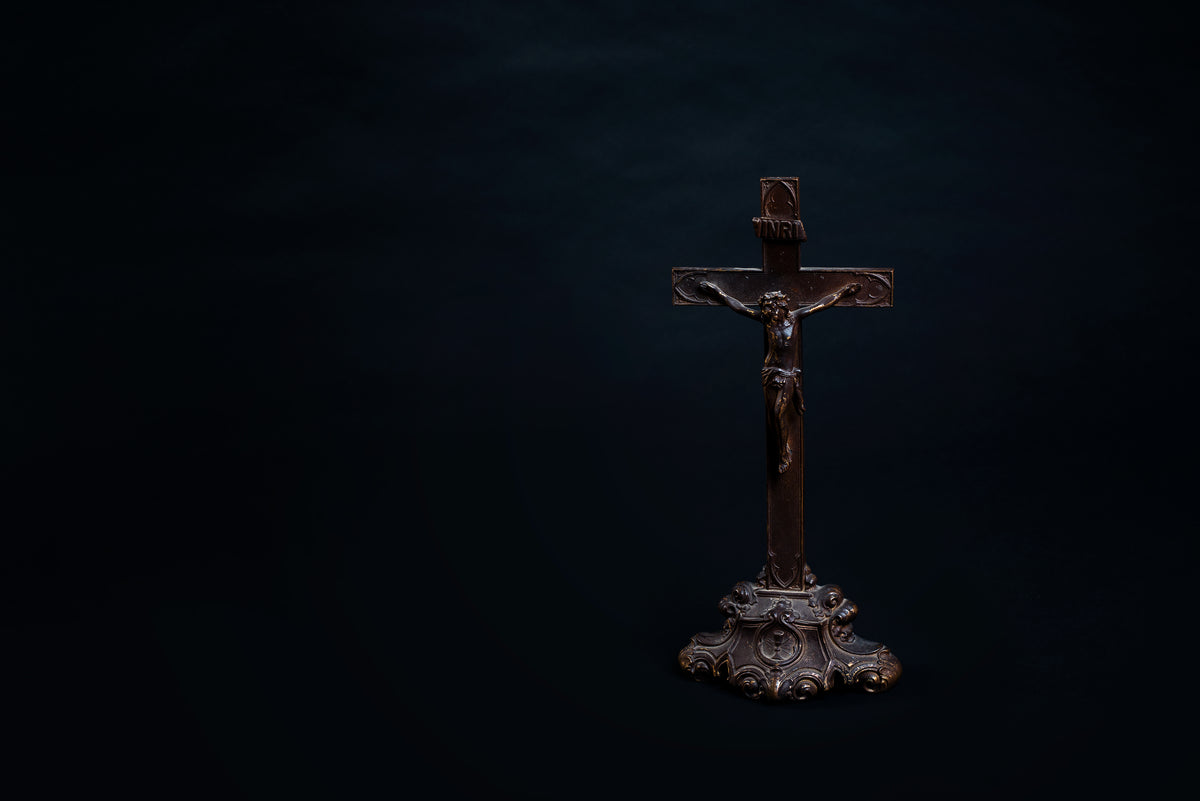 old wooden cross with carved figure and ornate stand