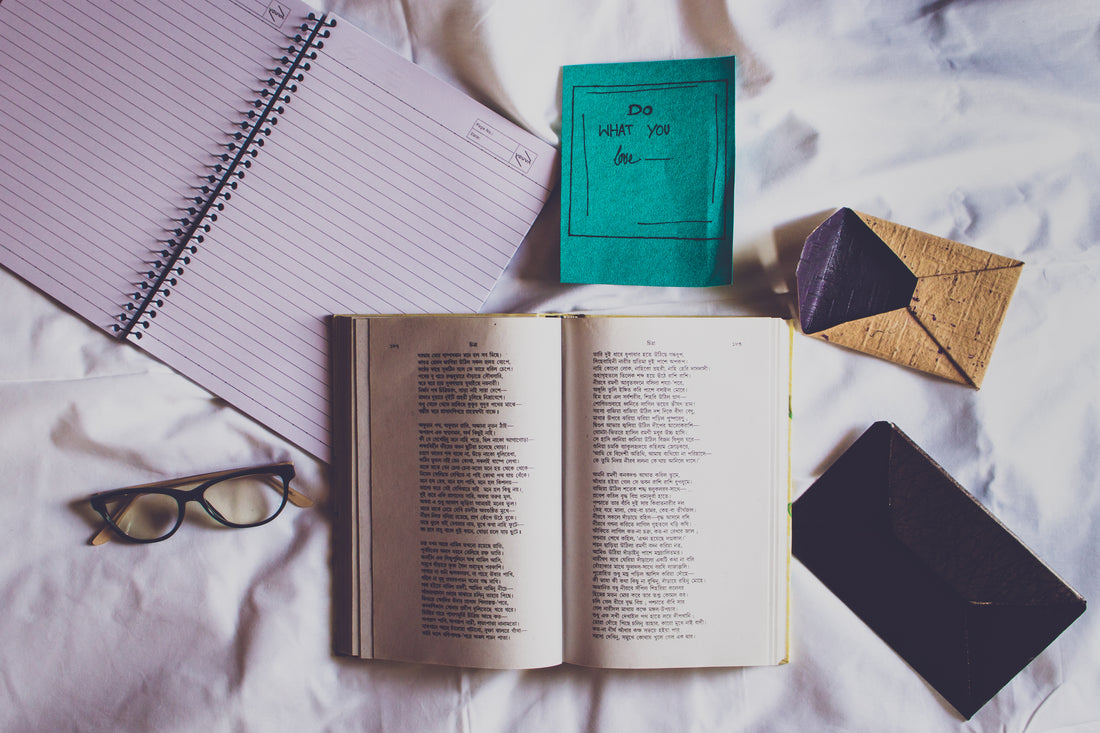 An open notebook beside pens and stationery