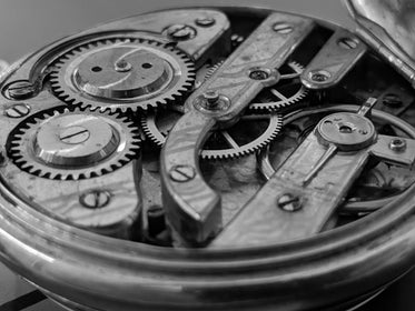 open timepiece exposing cogs and gear wheels