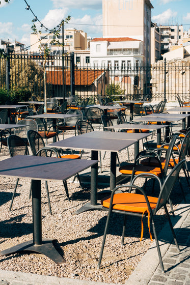 orange cushions on metal chairs in empty patio