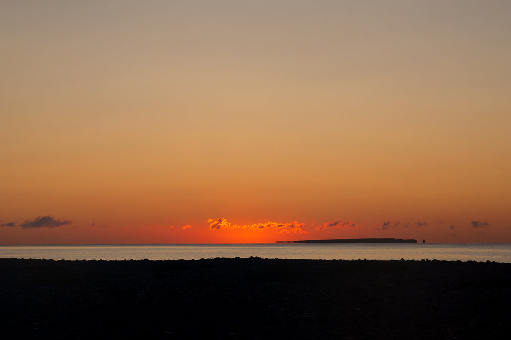 orange sunset over waters horizon