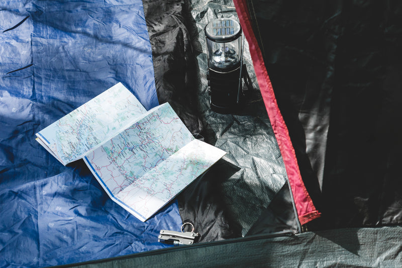 orienteering gear in campers tent - a book, a book and a pen on a blue background