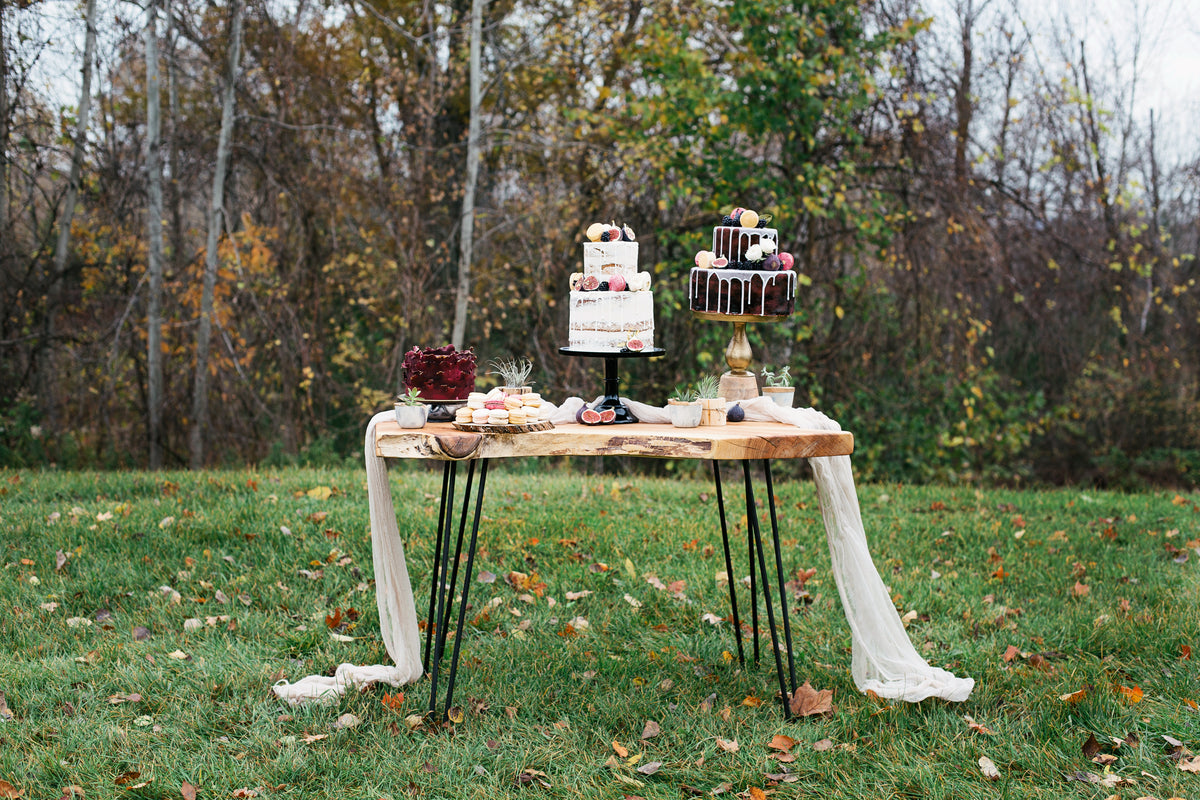 outdoor dessert table filled with cakes and macarons