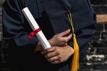 outside holding graduation cap and diploma