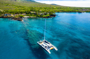 overhead view of sailboat anchored on coral reef