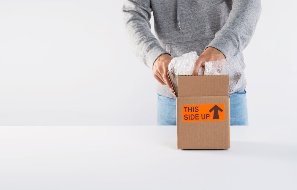 packing a box on top of a white table