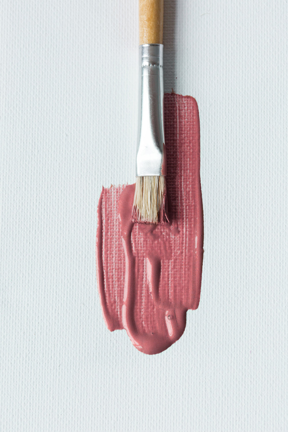 paintbrush with pink on canvas