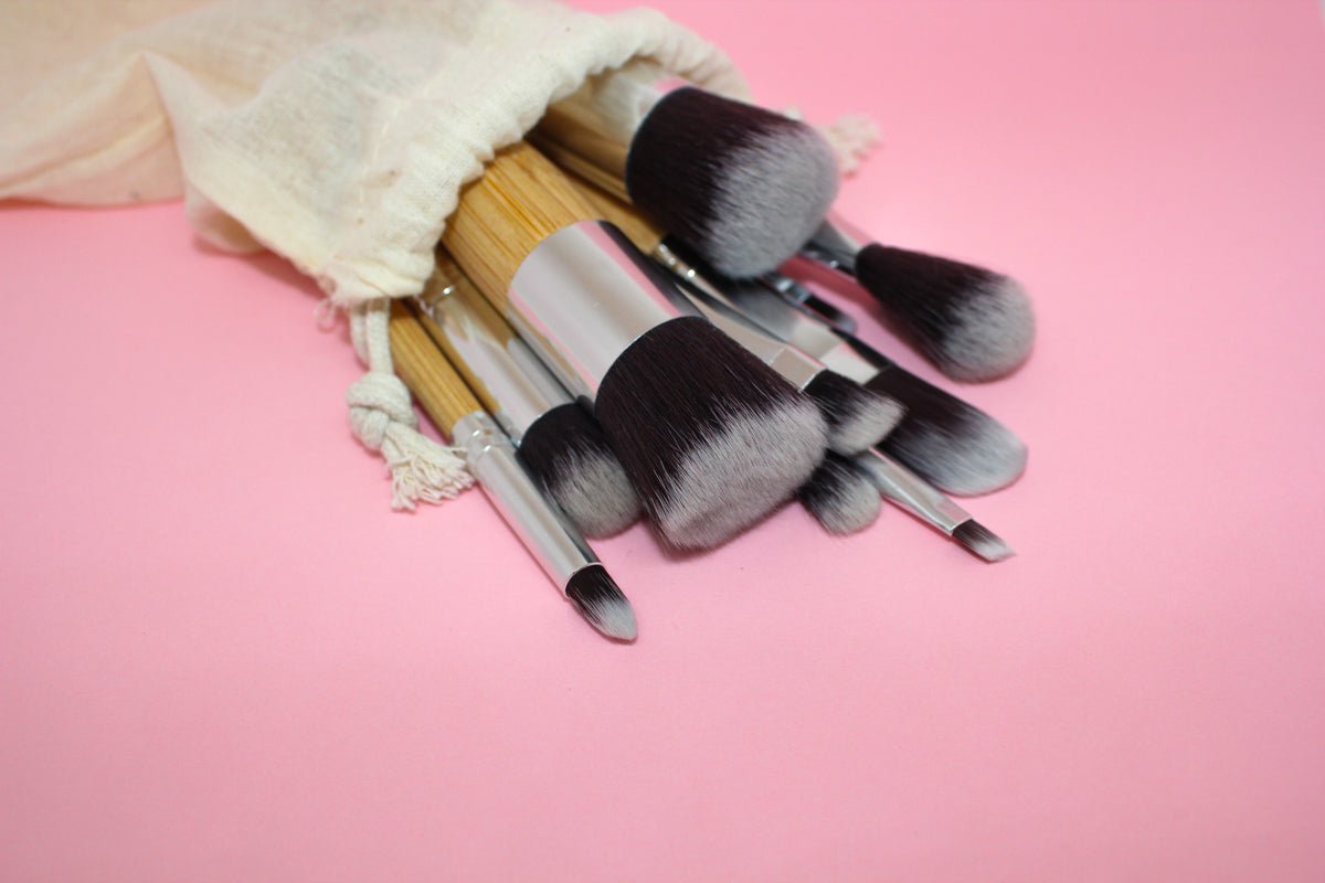 paintbrushes of different sizes spill onto a pink table